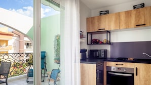 Una cocina moderna con armarios de madera, horno empotrado y microondas.