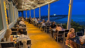 An outdoor dining area with tables and chairs, overlooking a pier and the sea. - HAPPY FUN  BLUE HOUSE for 8 people kids, pets friendly, 3 miles from the  beach🏖️ (Venice)