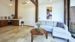 Un salon moderne avec un canapé gris, une table basse en bois et un tableau accroché au mur.