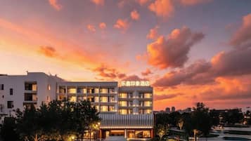 Un hotel con fachada moderna, varios pisos y una entrada bien iluminada.
