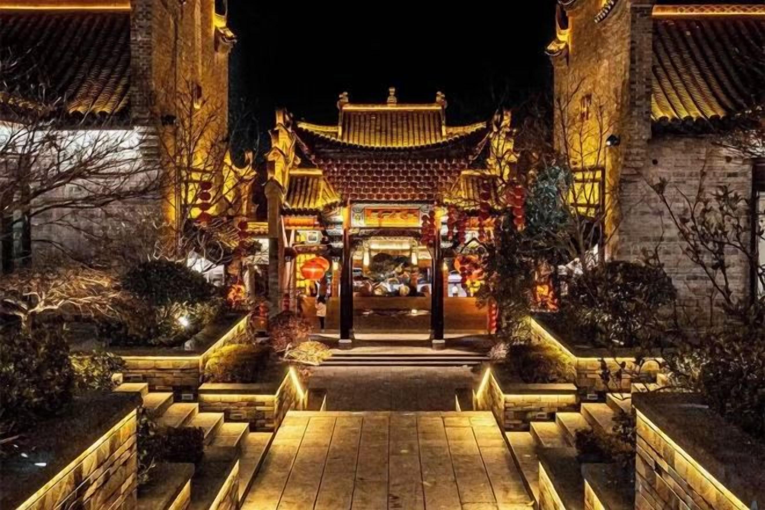 Un edificio tradicional con tejado de tejas, una entrada central y una escalera que lleva a él.
