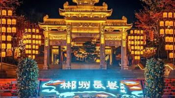 A traditional Chinese building with a prominent entrance and illuminated lanterns.