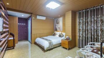 Una habitación de hotel con cama, mesita de noche y una silla.