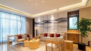A modern hotel lobby with a large sofa set, a coffee table, and a potted plant. - Aile Holiday Hotel (Sanming)