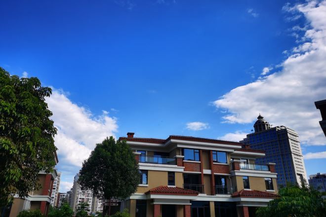 A multi-story building with a flat roof, large windows, and a modern architectural style.