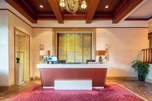 A reception desk with a large window, a chandelier, and a red carpeted floor. - Aile Holiday Hotel (Sanming)