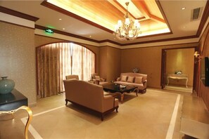 A hotel lobby with a sofa set, a coffee table, a TV, and a chandelier. - Aile Holiday Hotel (Sanming)