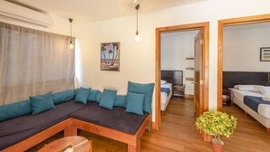 A modern living room with a sofa, a small wooden table, and a potted plant.