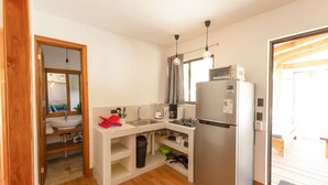 A compact kitchen with a sink, stove, and refrigerator.