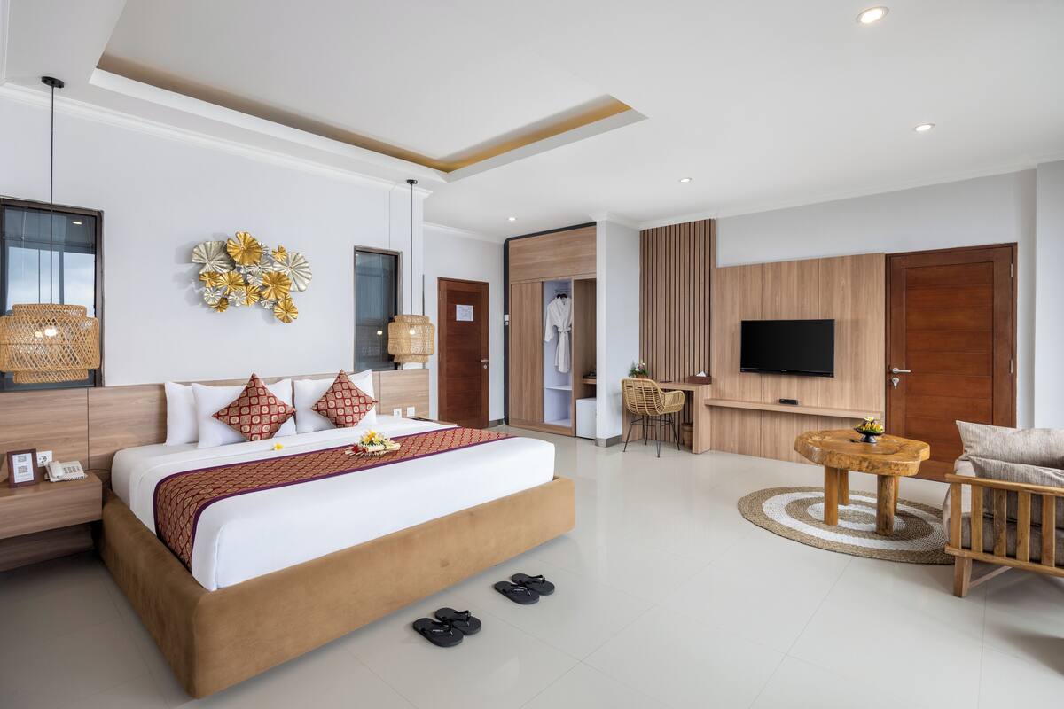 Een moderne hotelkamer met een groot bed, een bureau, een televisie en een zithoek.