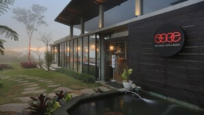 Een modern gebouw met een glazen gevel, een houten buitenkant, en een bord waarop 