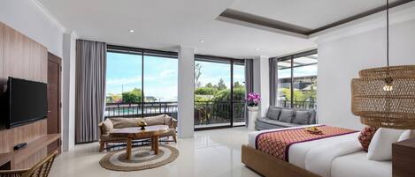 A modern hotel room with a large balcony, a sofa, a bed, a TV, and a dining area.