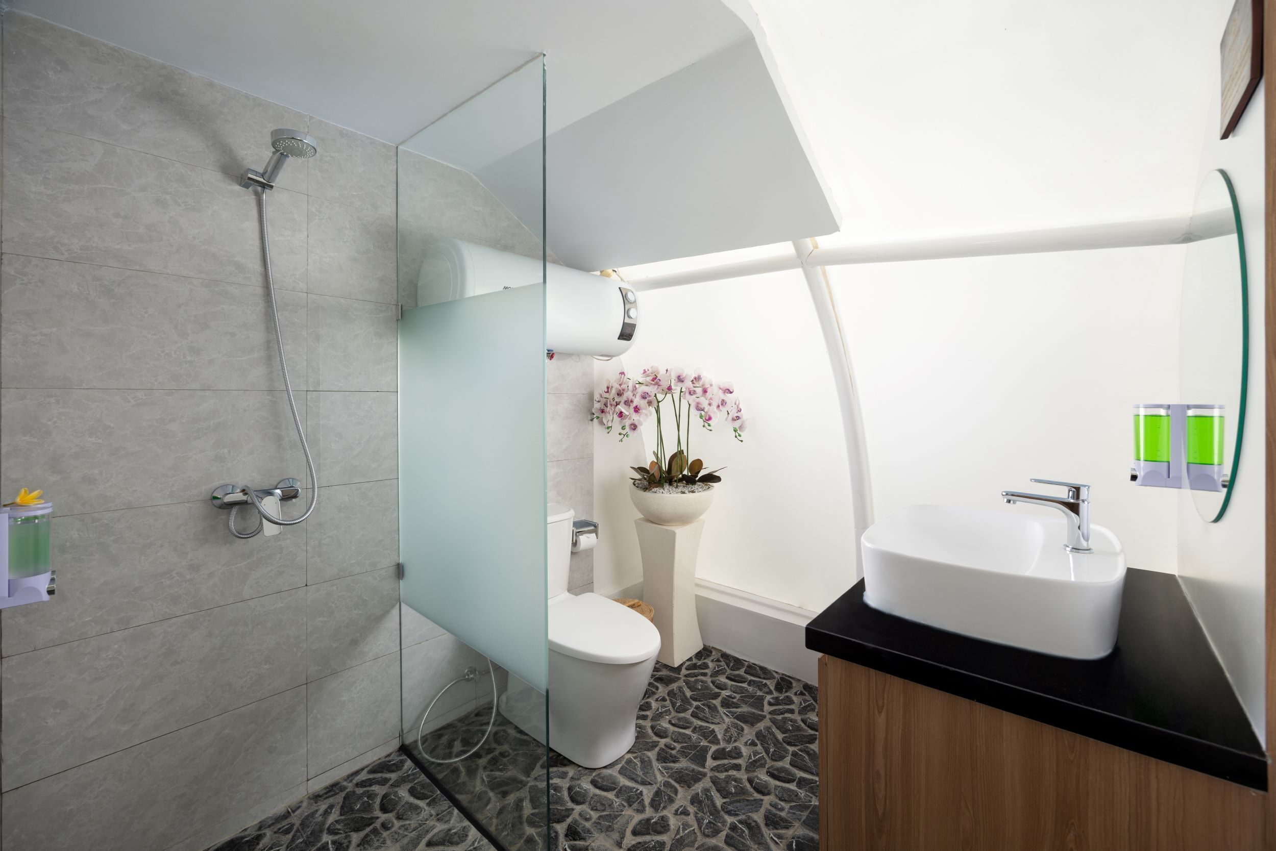 Un baño moderno con ducha, inodoro y lavabo.
