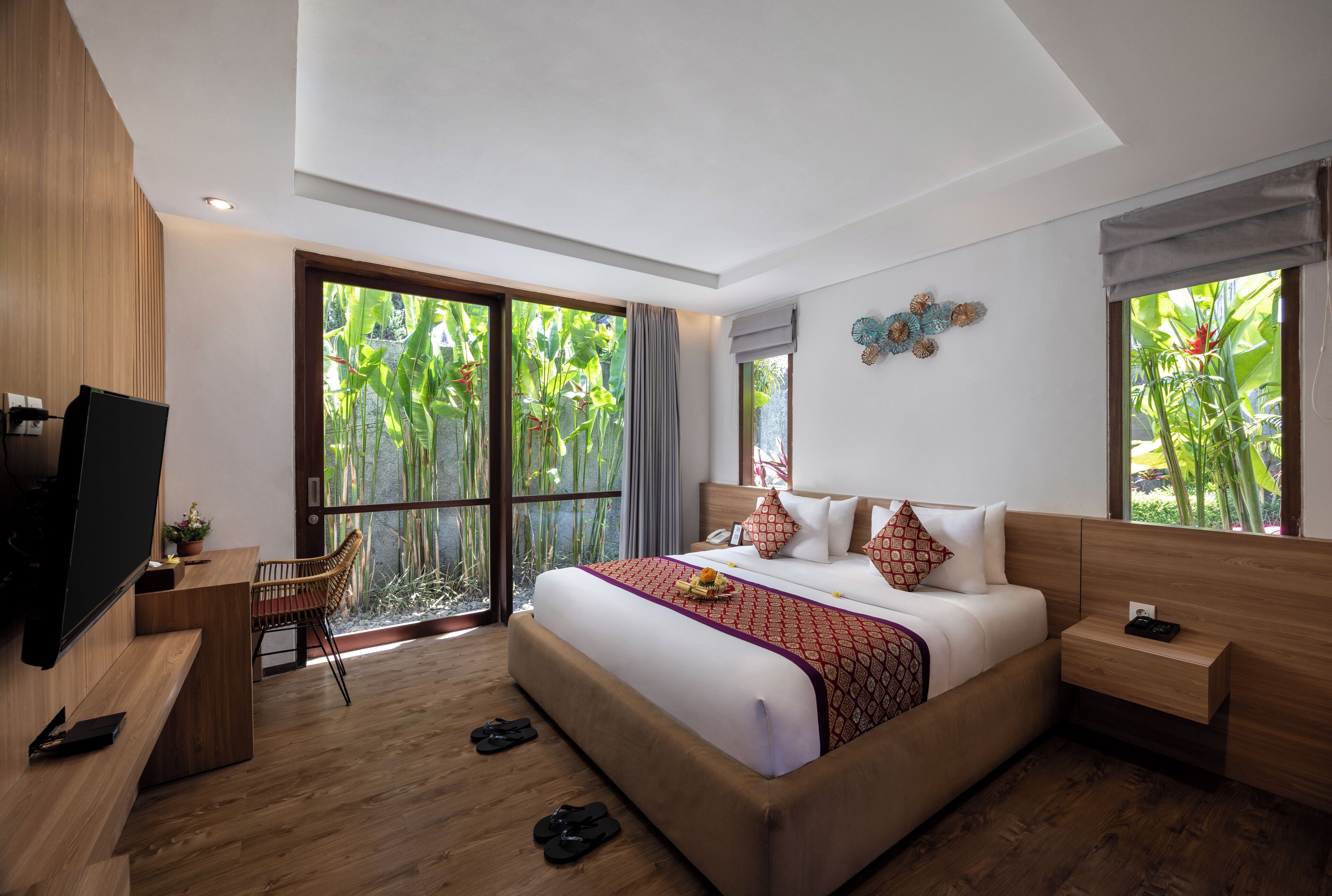 Een moderne hotelkamer met een groot bed, een bureau en een televisie.