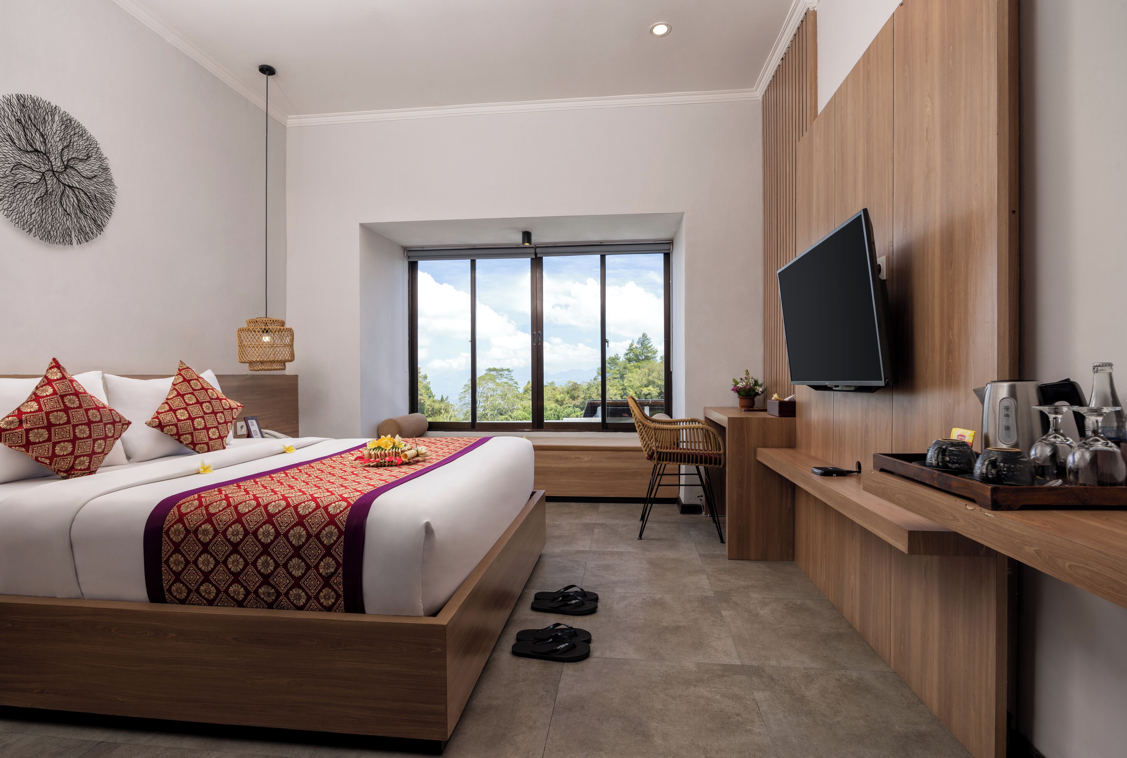 Habitación de hotel moderna con una cama grande, un escritorio, un televisor y vistas al exterior.