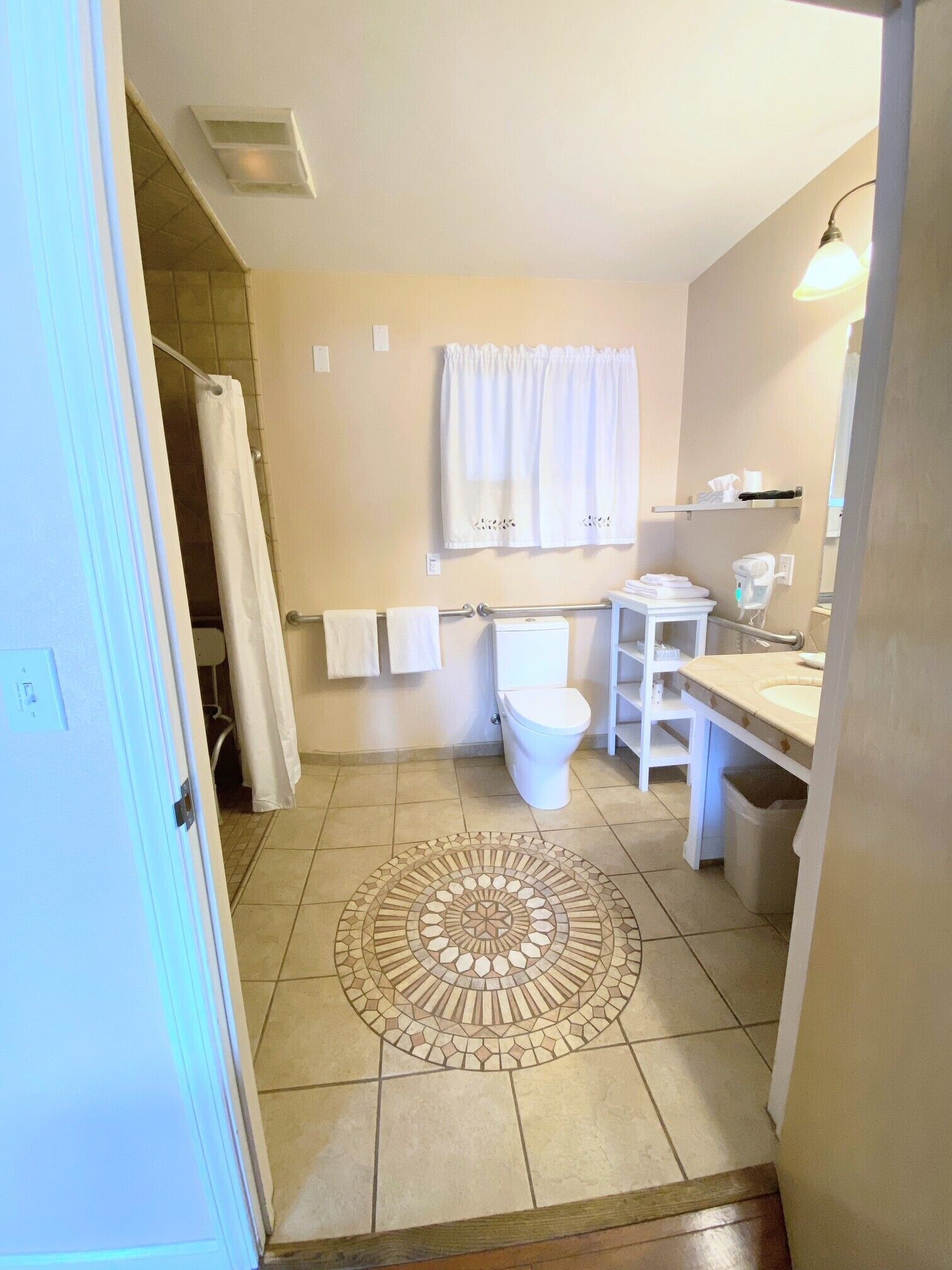 A bathroom with a toilet, sink, and shower area.