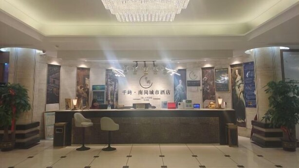 A hotel reception area with a chandelier, reception desk, seating, and artwork. - Nangang City Hotel (Shenzhen)