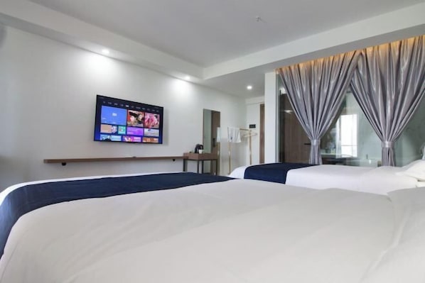 A hotel room with two beds, a flat-screen TV mounted on the wall, and a large window with curtains. - Holiday inn Aegean Port (Huidong)