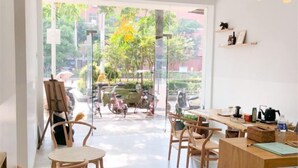 A modern interior with a large window, wooden furniture, and a view of bicycles outside.