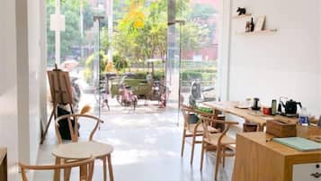 A modern interior with a dining area, a painting on the wall, and a view of the outside.