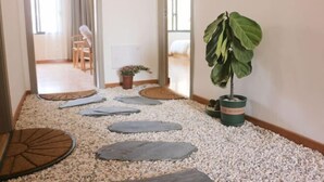 A pathway with stepping stones leading to a room with a bed and a potted plant.