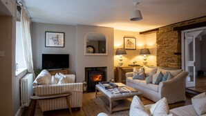 Una sala de estar acogedora con chimenea, televisión y asientos cómodos.