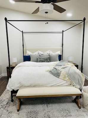 Restful retreat with a four-poster bed, plush pillows, and a cozy bench.