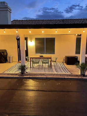 Relax in this serene outdoor space with a central table, comfortable chairs, and a cozy bench.