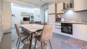 Una cocina moderna con comedor, horno empotrado y televisor.