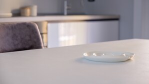 Una cocina moderna con encimera blanca, un lavabo y una silla.