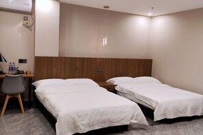 A hotel room with two single beds, a desk with a chair, a wooden headboard, and a hanging light fixture. - Dalian Jiayan Collection Hotel (Dalian)
