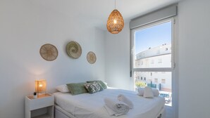 Une chambre à coucher comprenant un lit, une table de chevet, une lampe et des éléments décoratifs fixés au mur.