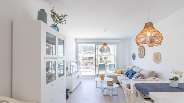 A bright, open-plan living space with a kitchen, dining area, and a view of the outdoors.