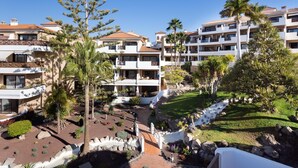 Um resort com edifícios de vários andares, piscinas ao ar livre e jardins bem cuidados.