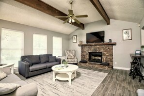 Relax in this stylish living room with a stone fireplace, flat-screen TV, and comfortable seating area.