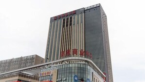 A tall building with vertical lines and a sign that reads "Xi'an Commercial Center". - Zhoushan Xinxiting Grand Hotel (Zhoushan)
