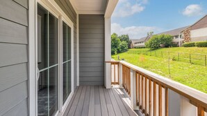 Ein Balkon mit Blick auf einen Rasen und angrenzende Häuser.