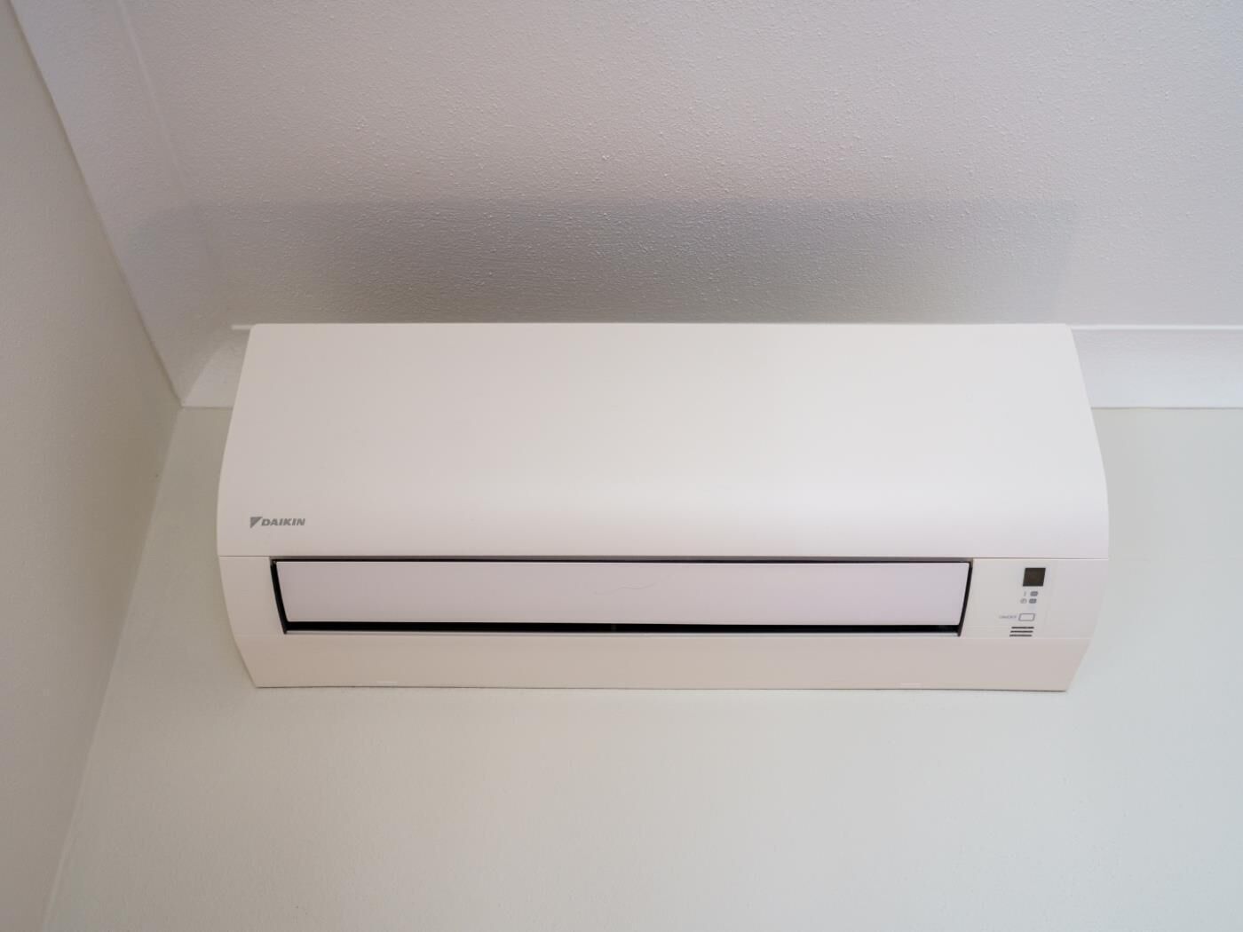A white Daikin air conditioner unit mounted on a wall.