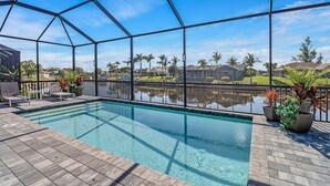 Une piscine offrant une vue dégagée sur le quartier environnant, avec ses maisons et ses palmiers.