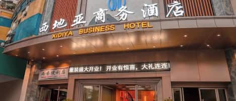 Um hotel com uma placa chamativa para 'XIDIYA BUSINESS HOTEL'.