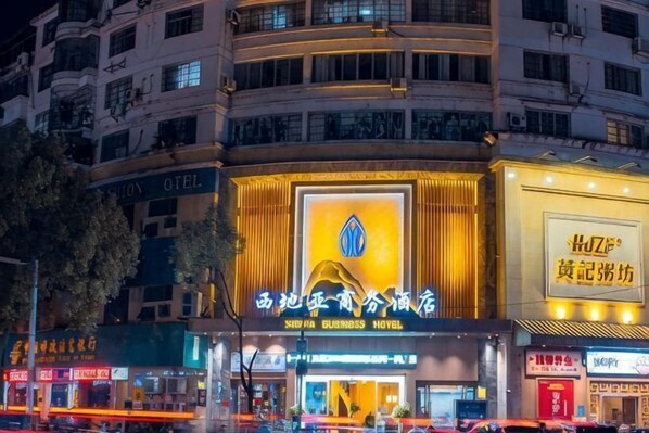 Un hôtel avec une enseigne bien visible, de nombreux étages et situé sur une rue animée.