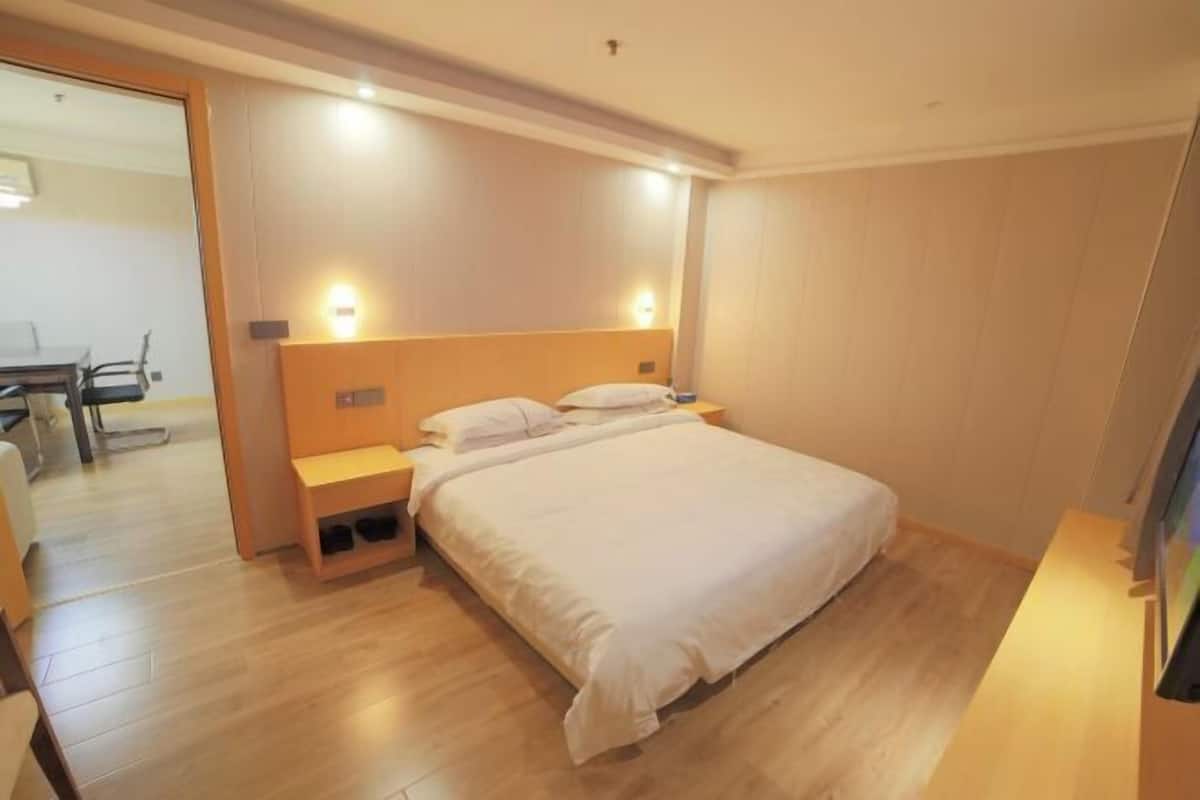 Una habitación de hotel con cama, mesitas de noche y un escritorio con silla.