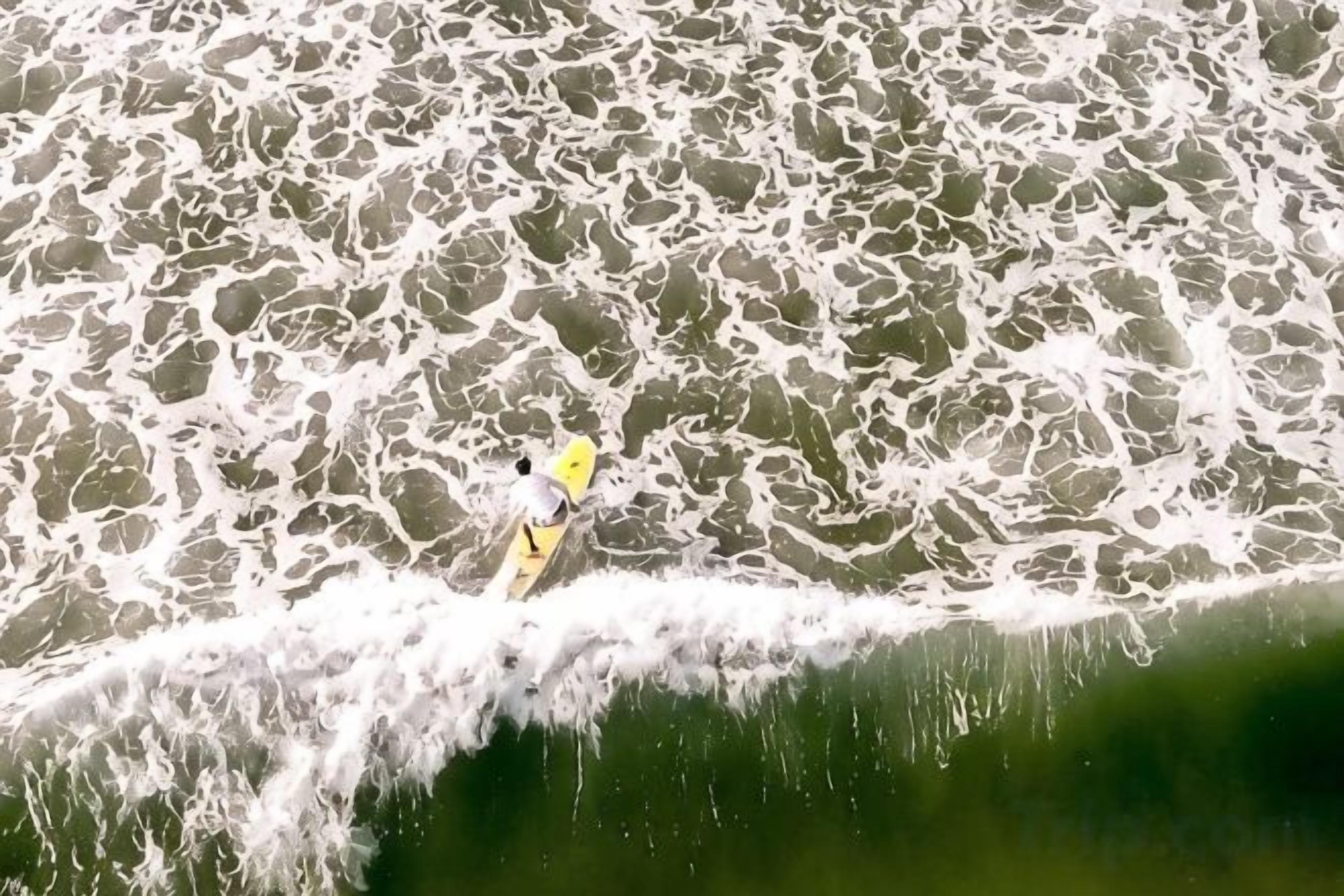 Una persona surfeando sobre el agua.