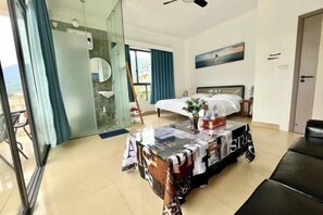A hotel room with a bed, a table with a magazine cover, a window with curtains, and a view of the outdoors. - Time and Sea Inn (Shenzhen)
