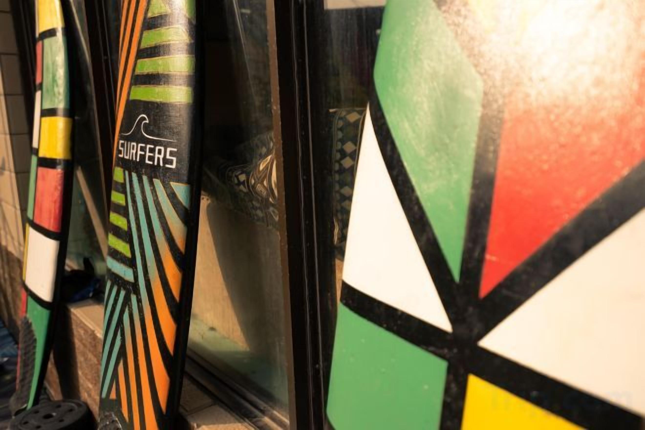 Een close-up van surfplanken, waarop de tekst 'SURFERS' staat.