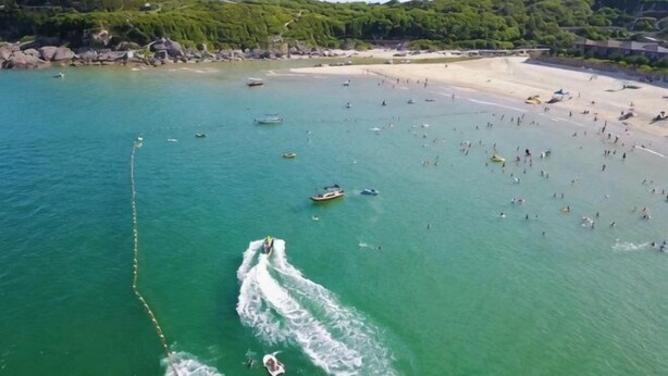 A coastal area with boats, a beach, and a forested hill. - Time and Sea Inn (Shenzhen)