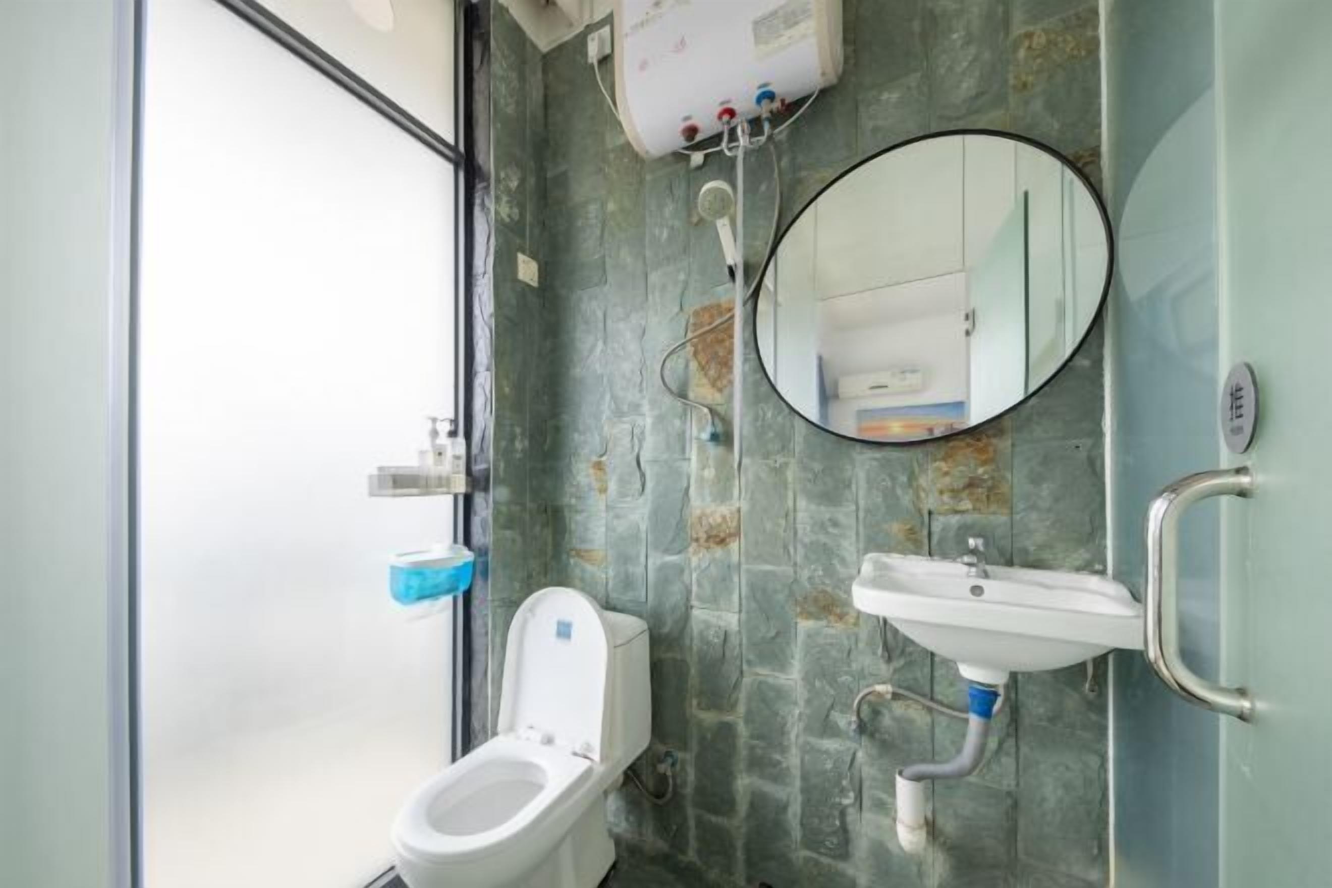 Un baño con inodoro, lavamanos, espejo y ducha.