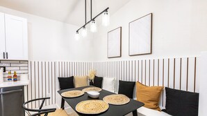 Een moderne keuken met een eettafel, stoelen en een inbouwbank.