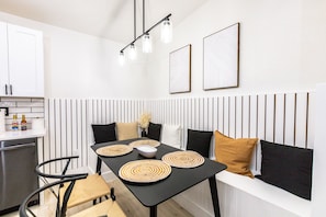 Una cocina moderna con una mesa de comedor, sillas y un banco empotrado.