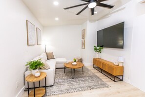 A modern living room with a sofa, coffee table, and TV.